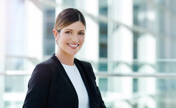 The smile of success. Cropped portrait of an attractive young businesswoman smiling while sitting in a modern office. — Fotografia de Stock