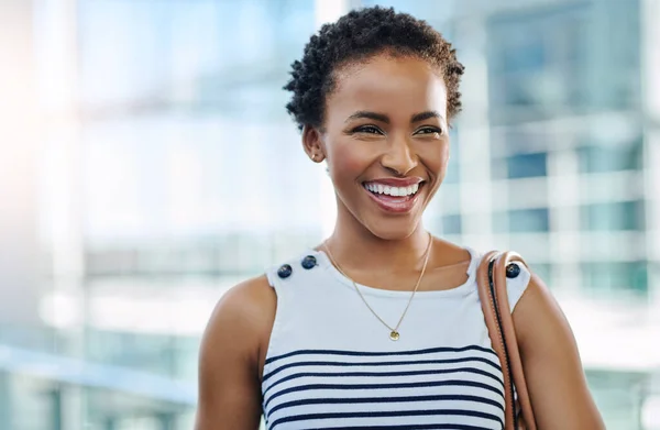 Shes the leading lady. Cropped shot of an attractive young businesswoman smiling while standing in a modern office. — Stockfoto