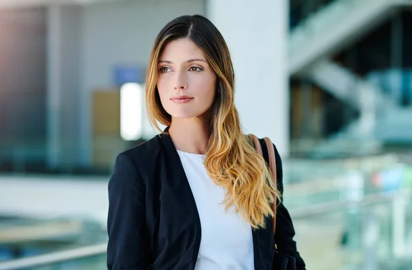 Keep your goals in mind. Cropped shot of an attractive young businesswoman looking thoughtful while standing in a modern office. — стоковое фото