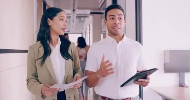 4k video filmación de dos jóvenes colegas de negocios charlando mientras caminan a través de la oficina — Vídeos de Stock