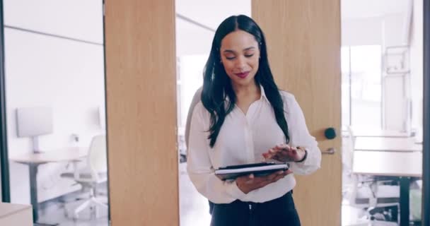 4k video footage of a cheerful young businesswoman greeting her colleague as she walks through her office — Stockvideo