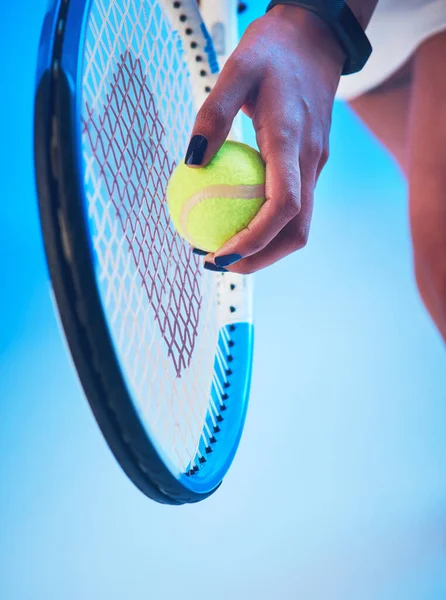Її сервісна гра знаходиться в точці. Обрізаний знімок невпізнаваної молодої тенісистки готується служити на синьому фоні . — стокове фото