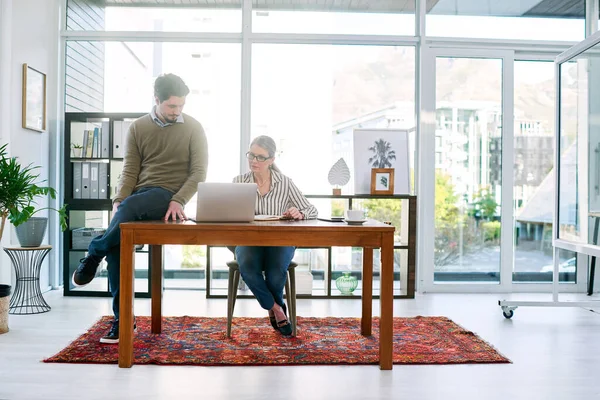 Pensando en nuevos planes. Fotografía de dos empresarios trabajando juntos en una laptop en una oficina. — Foto de Stock
