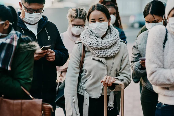 Navegando por um novo modo de vida. Tiro de um grupo de jovens usando máscaras enquanto viajam em uma cidade estrangeira. — Fotografia de Stock