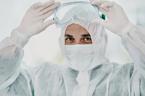 Il est temps d'anéantir ce virus. Prise de vue d'un jeune homme revêtant son équipement de protection avant le processus de décontamination. — Photo