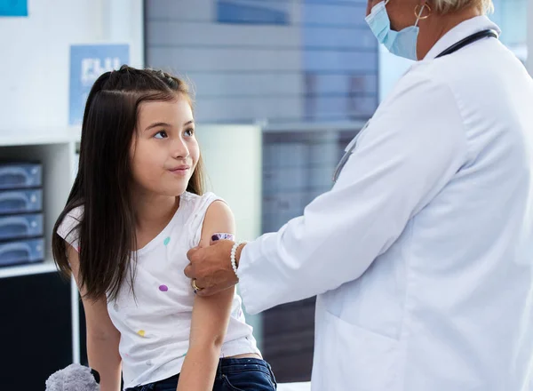 Nie było tak źle. Ujęcie małej dziewczynki szczepionej przez lekarza w szpitalu.. — Zdjęcie stockowe