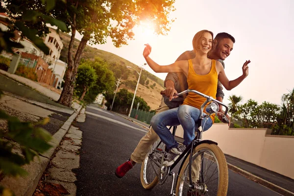 사랑은 아름답지 타는걸즐겨라. 함께 자전거를 타고 즐기고 있는 행복 한 젊은 부부의 사진. — 스톡 사진