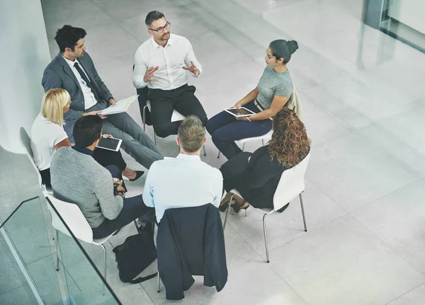 Ідеї течуть. Знімок групи співробітників, які розмовляють разом, сидячи в колі в офісі . — стокове фото