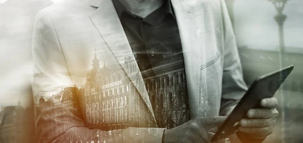 Inalámbrica en el paisaje urbano. Múltiple toma de exposición de un hombre de negocios usando una tableta digital superpuesta en un paisaje urbano. — Foto de Stock