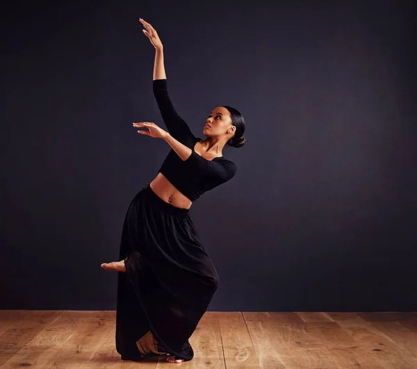 Mysteries of the dance. Female contemporary dancer in a dramatic pose against dark background. — Stock Photo, Image