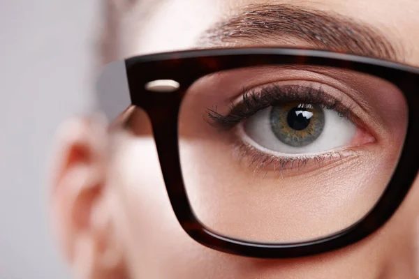 Faire une déclaration de mode. Gros plan portrait en studio d'une jeune femme portant des lunettes sur un fond gris. — Photo