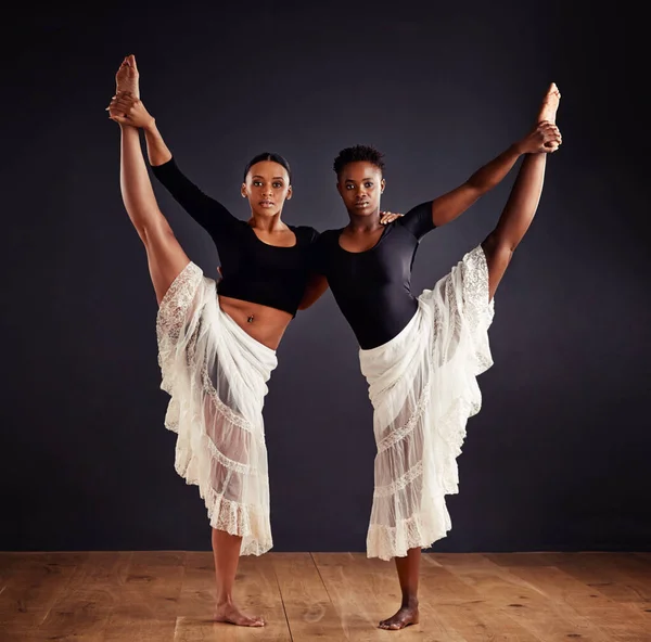 Irmãs em simetria. Duas jovens dançarinas contemporâneas usando uma saia branca macia para efeito dramático. — Fotografia de Stock