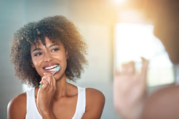 Le piace l'igiene orale. Colpo ritagliato di una giovane donna che si lava i denti in bagno. — Foto Stock