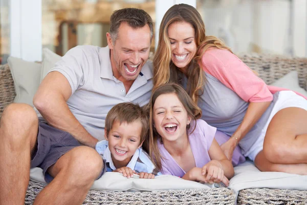 彼らは楽しみ方を知っている。4人の幸せな若い家族の肖像画一緒にパティオに座って. — ストック写真