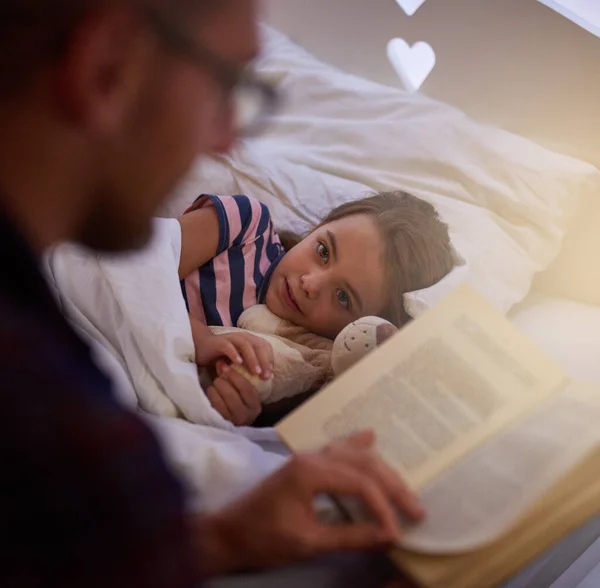 Готовлю ее ко сну. Снимок отца, читающего сказку на ночь своей дочери. — стоковое фото