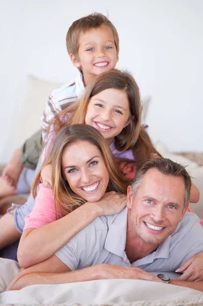 A família é tudo sobre equilíbrio. Retrato de uma jovem família feliz de quatro pessoas empilhadas umas em cima das outras. — Fotografia de Stock