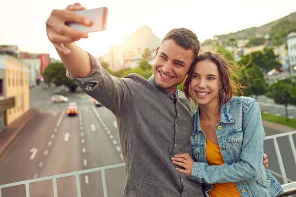 Sentimentální selfie. Shot of a happy young couple taking a selfie together in the city. — Stock fotografie