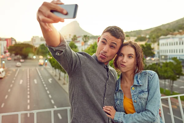 Začneme být divní. Shot of a happy young couple taking a selfie together in the city. — Stock fotografie