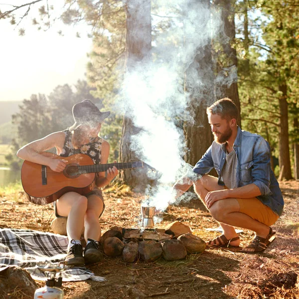 캠프파이어 노래. 야영지에서 남자 친구를 위해 기타를 치고 있는 젊은 여자의 사진. — 스톡 사진