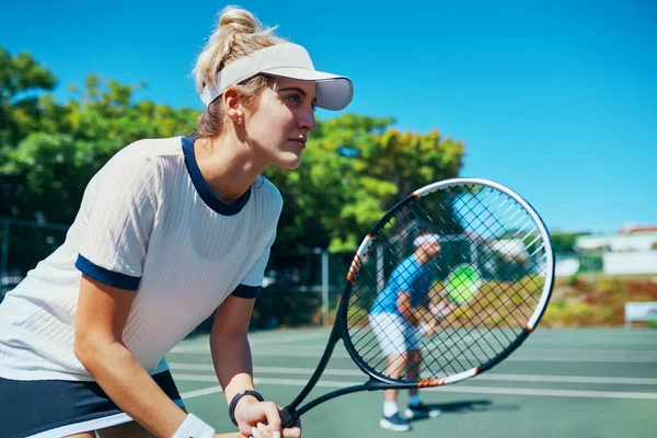 Practica ganar todos los días. Captura recortada de una atractiva joven jugadora de tenis jugando junto con un compañero de equipo al aire libre en una cancha. —  Fotos de Stock