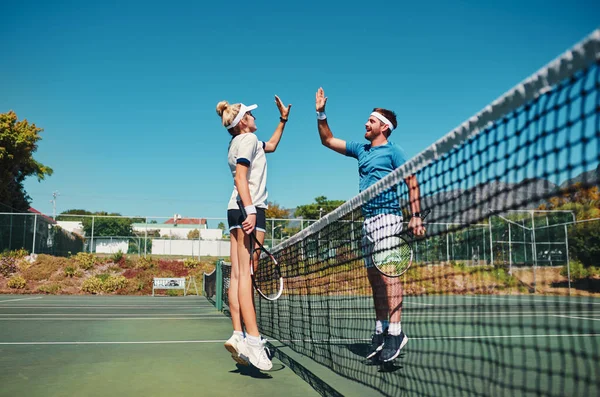 Együtt a győzelemben. Teljes hossz felvétel két fiatal teniszezőről, akik pacsit adnak egymásnak a pályán.. — Stock Fotó