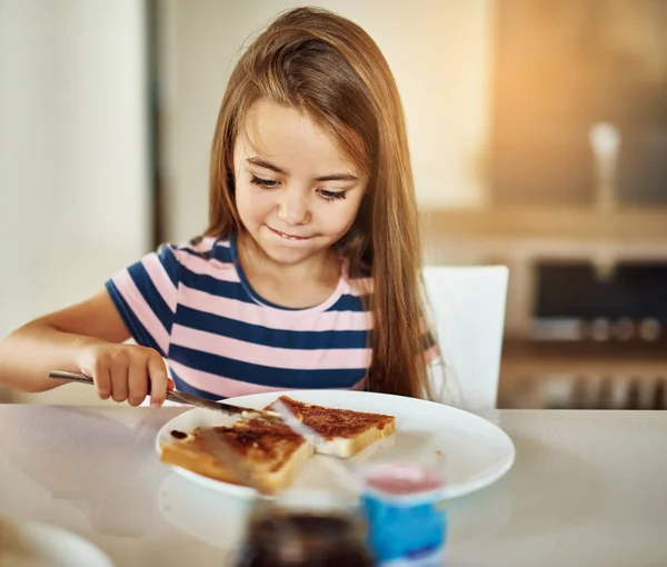 Kiválasztja a saját reggelijét. Vágott kép egy imádnivaló kislányról, aki a konyhában reggelizik.. — Stock Fotó