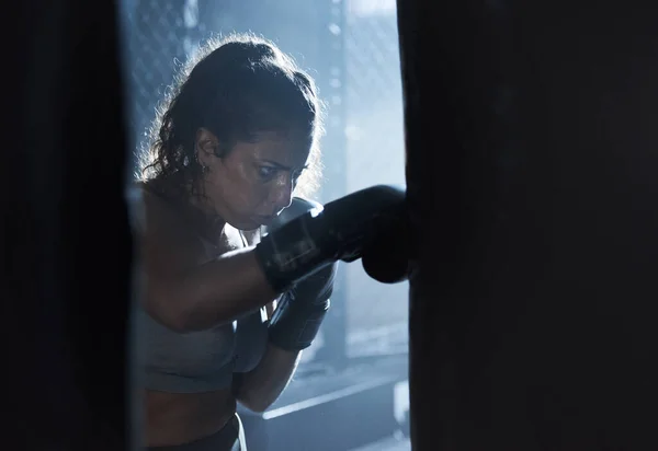 Pijn omzetten in macht. Shot van een sportieve jonge vrouw boksen in een sportschool. — Stockfoto