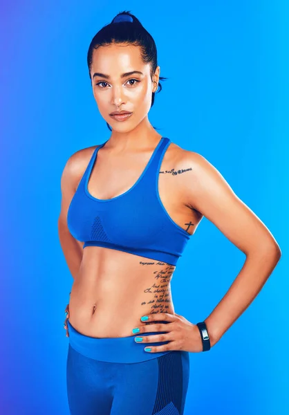 Förtroende föder resultat. Studio porträtt av en attraktiv ung idrottskvinna poserar mot en blå bakgrund. — Stockfoto