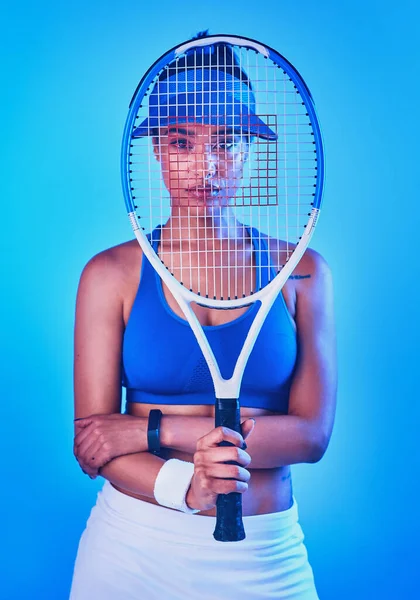 Je suis toujours prêt pour un match. Portrait recadré d'une jeune joueuse de tennis attirante posant sur un fond bleu. — Photo
