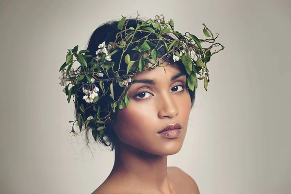 Um com a natureza. Retrato de estúdio de uma bela jovem usando uma coroa de flores na cabeça. — Fotografia de Stock