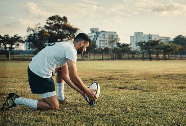 Vorbereitung auf den großen Kick. Aufnahme in voller Länge von einem hübschen jungen Rugbyspieler, der sich auf einen Tritt vorbereitet, während er tagsüber auf dem Feld trainiert. — Stockfoto