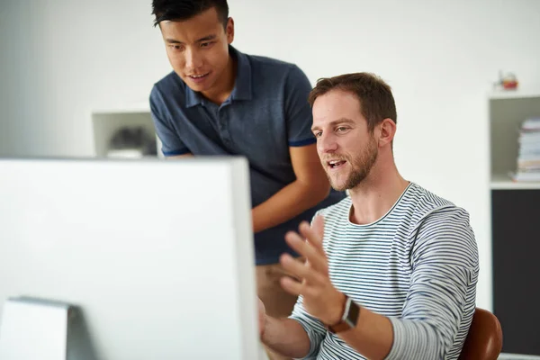 Creo que lo conseguimos.... Recortado de dos diseñadores trabajando juntos en un proyecto en una oficina. — Foto de Stock