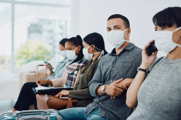 Nunca subestimes a importância da paciência. Tiro de um grupo de jovens usando máscaras em uma sala de espera. — Fotografia de Stock