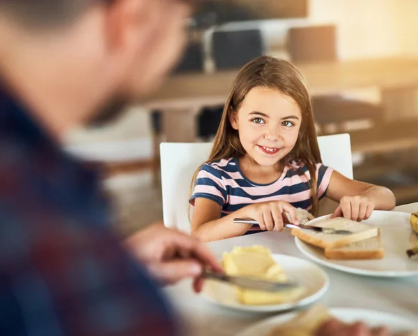 Merci pour le petit déjeuner, papa. Plan recadré d'une adorable petite fille prenant le petit déjeuner avec son père dans la cuisine. — Photo