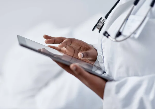 Weiterentwicklung ihrer Fähigkeiten durch digitale Technologie. Nahaufnahme eines nicht erkennbaren Arztes mit einem digitalen Tablet in einem Krankenhaus. — Stockfoto