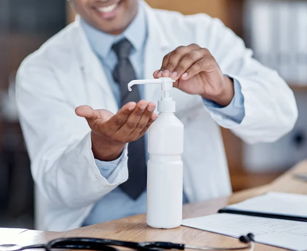 Desinfetar o máximo de vezes possível. Foto de perto de um médico irreconhecível usando desinfetante de mão enquanto trabalhava em seu escritório. — Fotografia de Stock