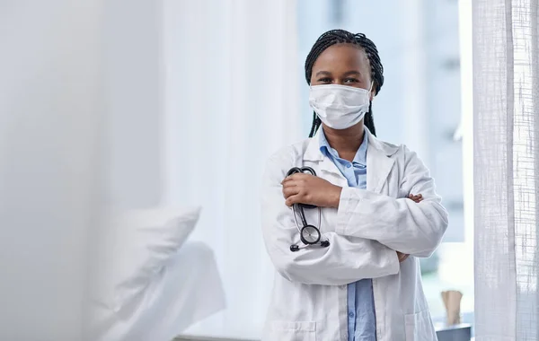 Mettre la passion dans les soins communautaires. Portrait d'un jeune médecin portant un masque facial et tenant un stéthoscope dans un hôpital. — Photo