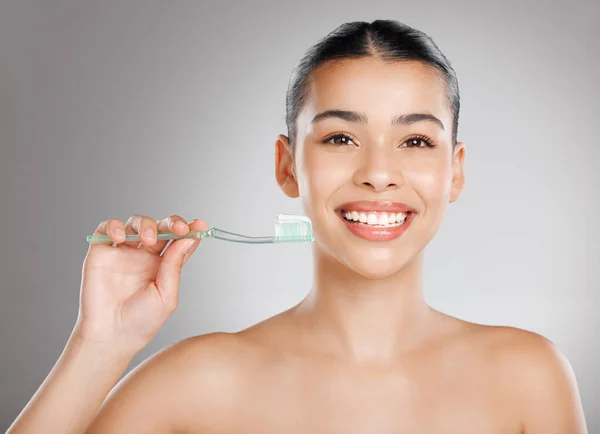 Nazwij to ubezpieczeniem na zęby. Studio ujęcie atrakcyjnej młodej kobiety myjącej zęby na szarym tle. — Zdjęcie stockowe