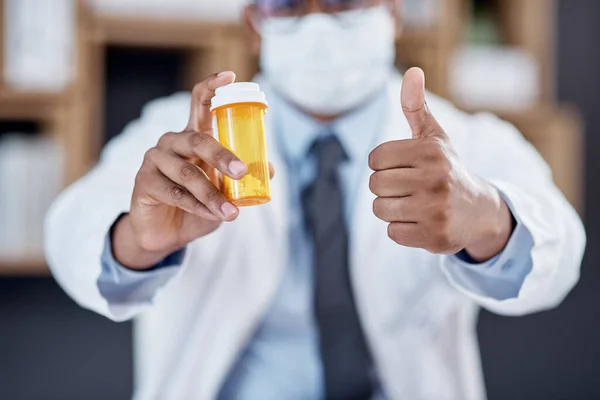 I guarantee this will work. Closeup shot of an unrecognisable doctor holding a bottle of pills and showing thumbs up in his office. — Stock Photo, Image