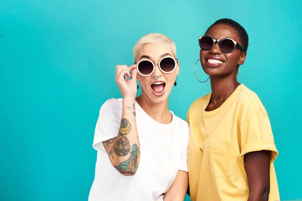 El futuro se ve brillante. Foto de estudio de dos mujeres jóvenes con gafas de sol sobre un fondo turquesa. —  Fotos de Stock