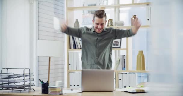 Mira quién gana. 4k video filmación de un joven hombre de negocios guapo bailando alegremente mientras trabajaba en una oficina. — Vídeo de stock