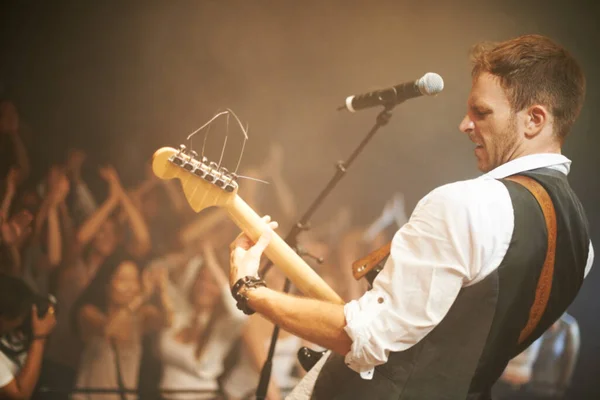 Música do coração. Tiro de um frontman em uma banda cantando no palco. — Fotografia de Stock