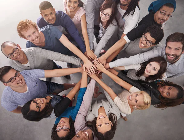 Samen moeten we de klus klaren. Hoge hoek portret van een business team staan in een cirkel met hun handen gestapeld. — Stockfoto