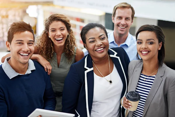 Reunindo-se para o sucesso das equipas. Retrato de um grupo de colegas sorridentes em pé em um escritório. — Fotografia de Stock