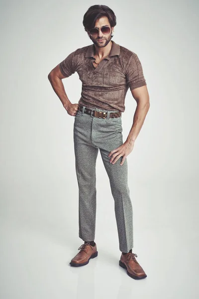 Я ніби велика справа.... Красивий чоловік у ретро 70-х одязі вражає позу в студії . — стокове фото