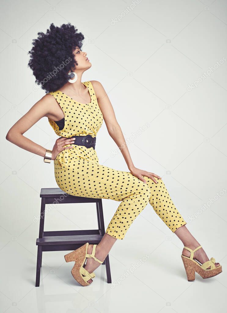 Shes got va va voom. A young woman wearing a 70s retro jumpsuit while in the studio.