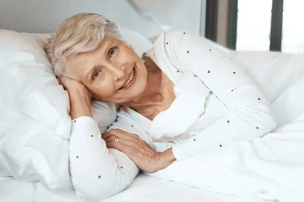 Відпочинок робить світ добрим. Знімок старшої жінки, що розслабляється в ліжку в будинку престарілих . — стокове фото