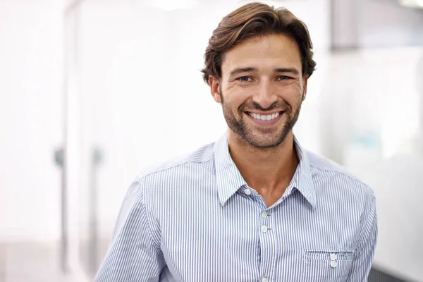 Hes a confident young businessman. Portrait of a handsome young businessman standing in his office. — Stock Photo, Image