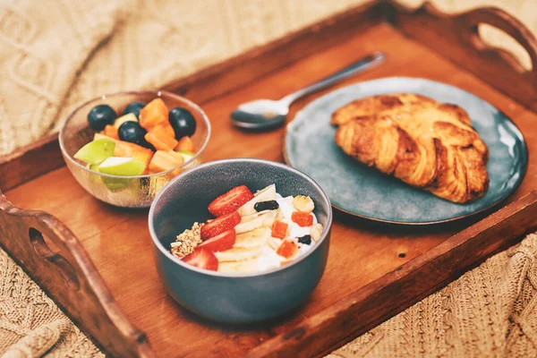 A boa comida é um estilo de vida. Tiro cortado de um café da manhã organizado em uma bandeja de madeira e servido na cama em casa. — Fotografia de Stock