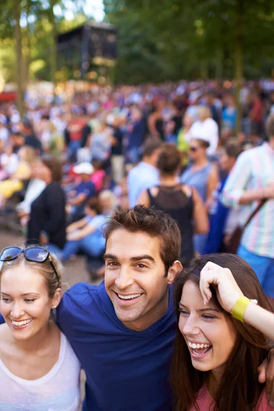 Amici al festival. Un gruppo di amici sorridenti che si godono un festival musicale con la folla sullo sfondo. — Foto Stock